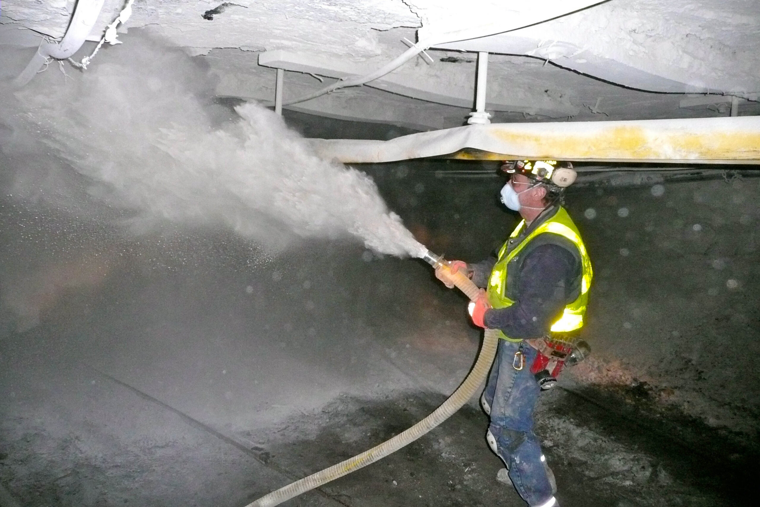 Coal miner spraying rock dust